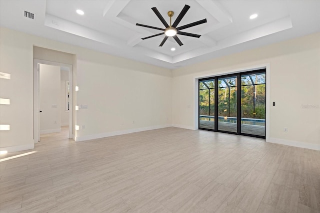 empty room with a raised ceiling and ceiling fan