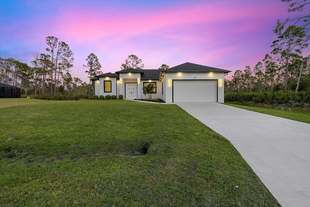 view of front of home featuring a garage and a yard