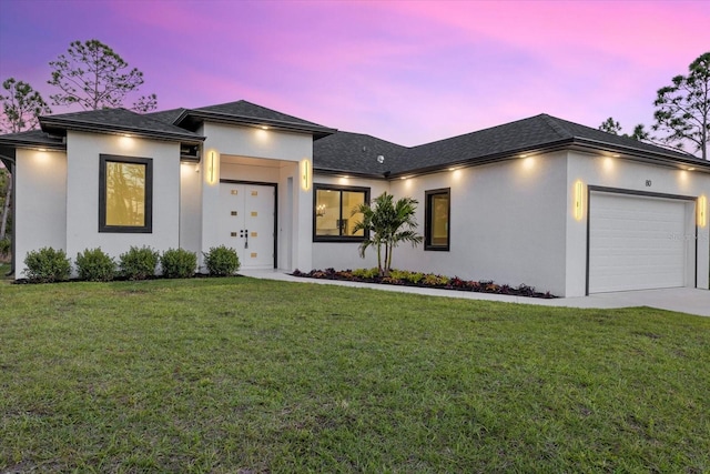 view of front of home with a garage and a yard