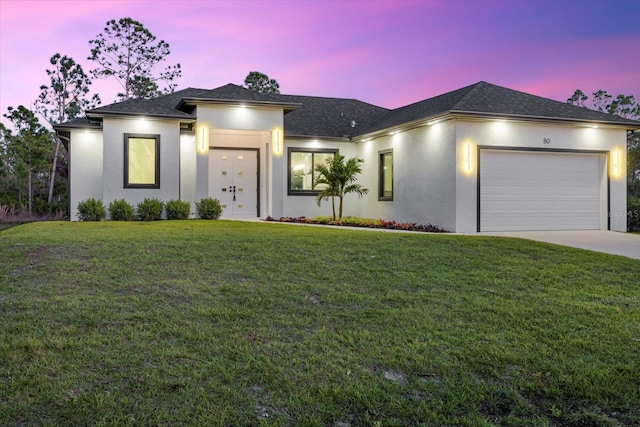 view of front of property with a garage and a lawn