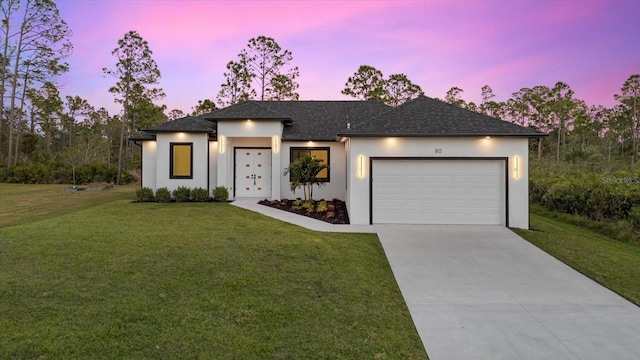 view of front of property with a garage and a lawn