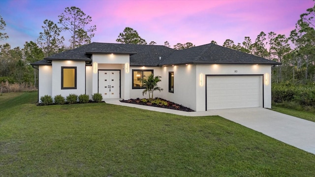 view of front of property with a garage and a yard