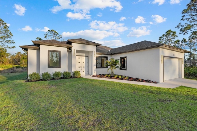 prairie-style house featuring a garage and a front lawn