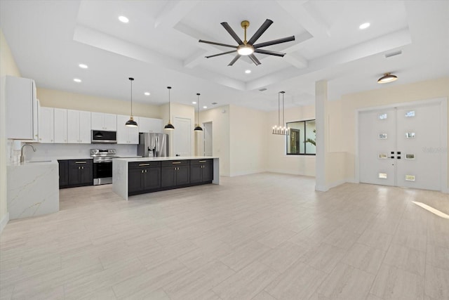 kitchen featuring coffered ceiling, white cabinetry, a center island, appliances with stainless steel finishes, and pendant lighting