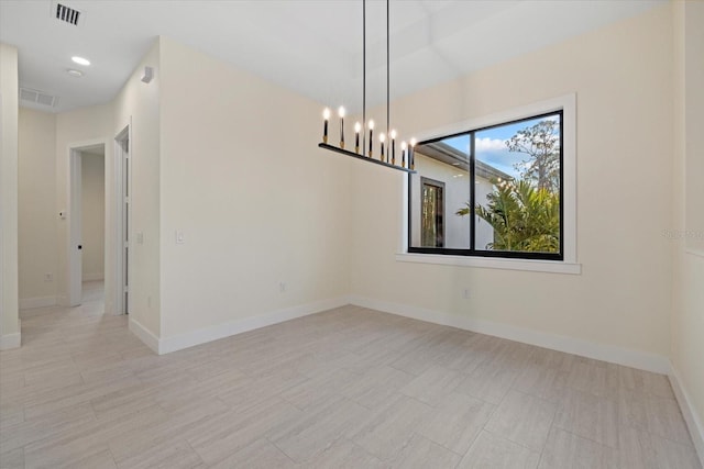 empty room featuring an inviting chandelier