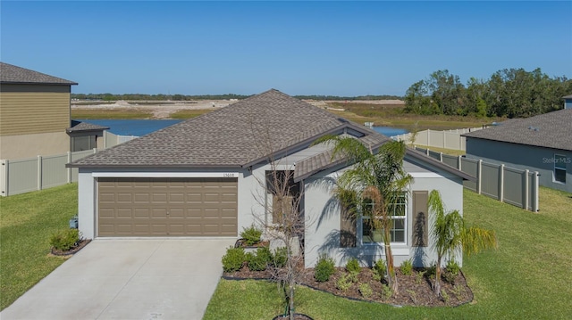 view of front of home with a water view, a garage, and a front lawn