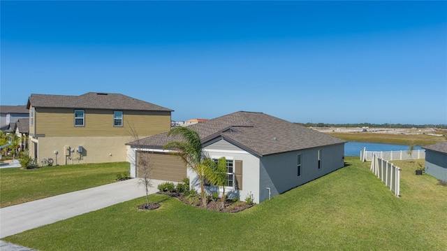 view of home's exterior featuring a water view, a garage, and a yard