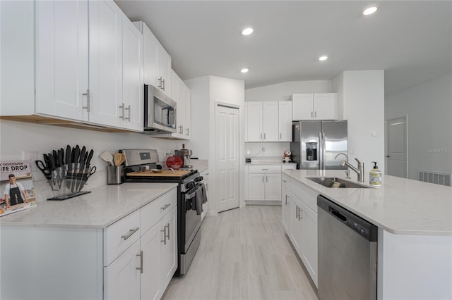 kitchen featuring appliances with stainless steel finishes, sink, a center island with sink, and white cabinets