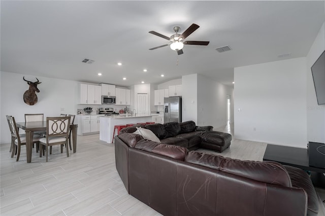 living room with vaulted ceiling, sink, and ceiling fan