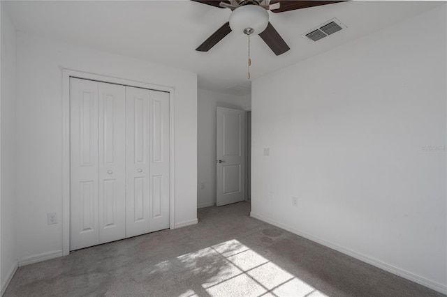 unfurnished bedroom featuring ceiling fan, a closet, and light carpet