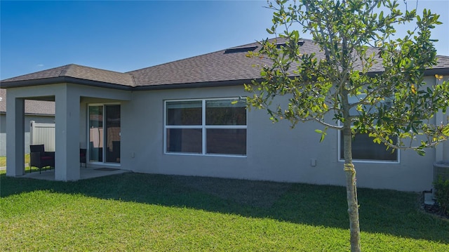 back of house featuring a patio area and a lawn