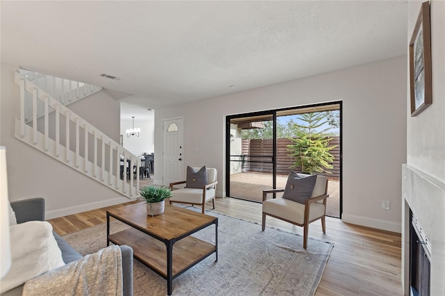 living room with light hardwood / wood-style flooring and a chandelier