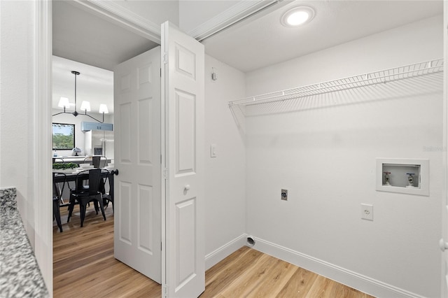 clothes washing area with wood-type flooring, washer hookup, hookup for an electric dryer, and a chandelier