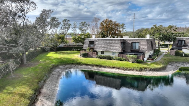 back of house featuring a yard and a water view