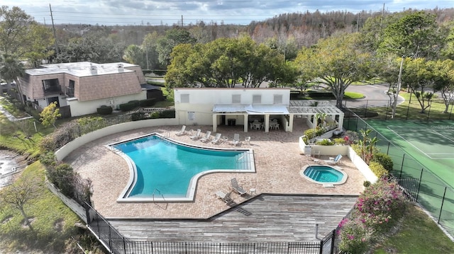 view of pool with a community hot tub, a wooden deck, and a patio area