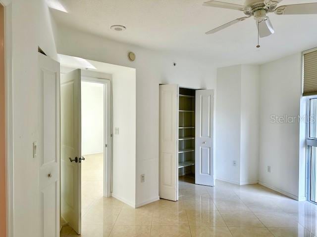 unfurnished bedroom with light tile patterned floors and ceiling fan