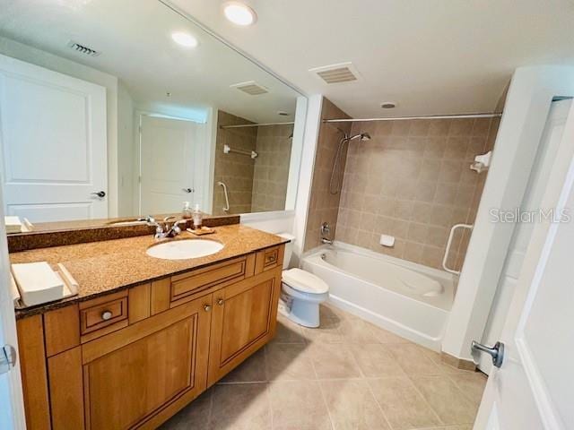 full bathroom with vanity, tile patterned flooring, tiled shower / bath combo, and toilet