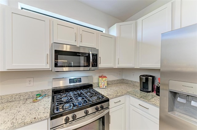 kitchen featuring white cabinetry, stainless steel appliances, and light stone counters