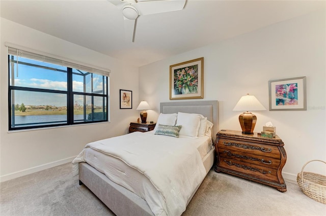 carpeted bedroom with a water view and ceiling fan