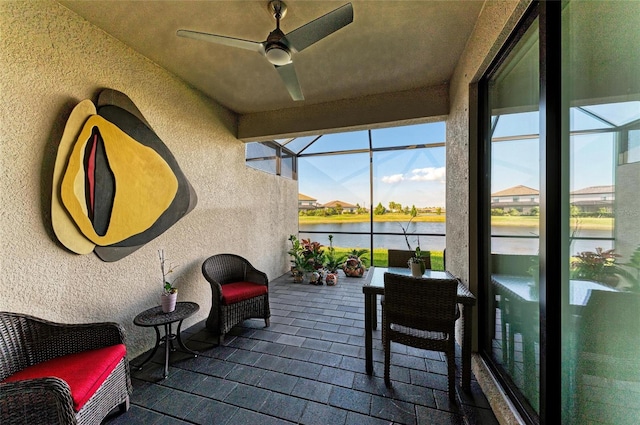 sunroom / solarium with a water view and ceiling fan