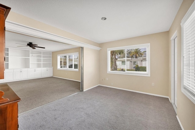 unfurnished living room with ceiling fan, carpet, and a textured ceiling