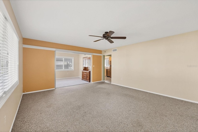 carpeted spare room with ceiling fan