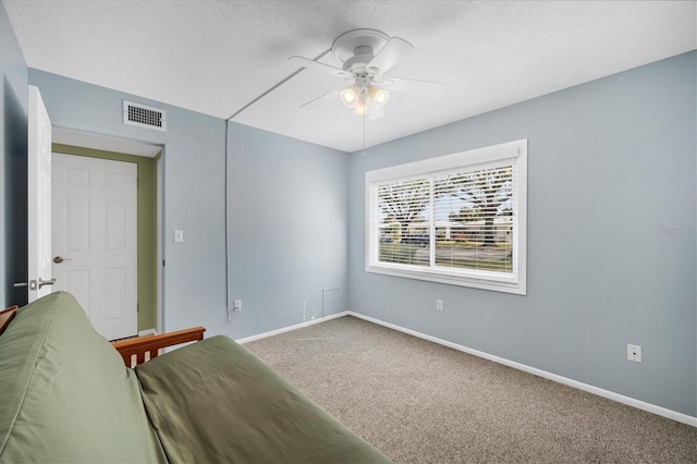 unfurnished room featuring ceiling fan, carpet, and a textured ceiling