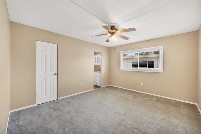 unfurnished bedroom featuring ceiling fan, ensuite bathroom, carpet, and a textured ceiling