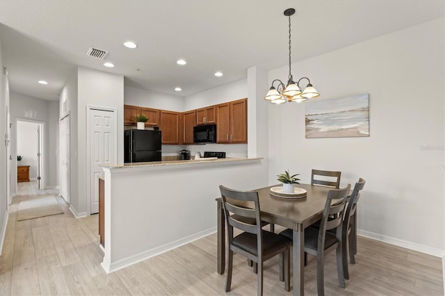 dining room with an inviting chandelier and light wood-type flooring