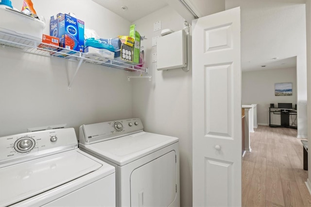 washroom with separate washer and dryer and light wood-type flooring