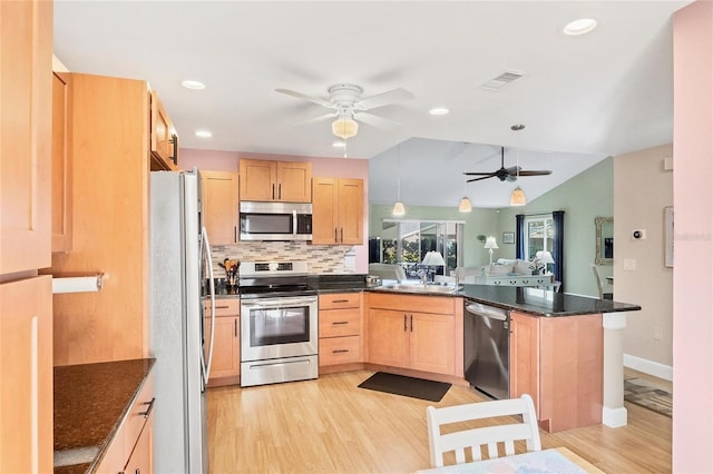 kitchen featuring appliances with stainless steel finishes, light brown cabinetry, light hardwood / wood-style floors, sink, and kitchen peninsula