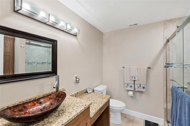 bathroom featuring vanity, a shower with shower door, and toilet