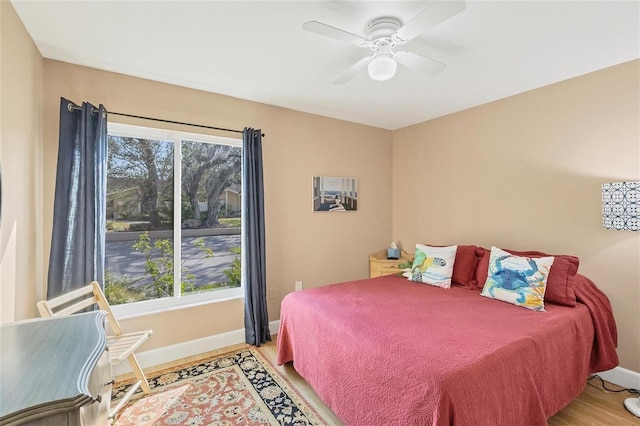 bedroom with ceiling fan, light wood-type flooring, and multiple windows