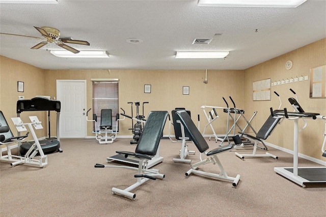 workout area with ceiling fan and a textured ceiling