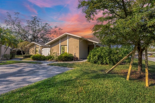 property exterior at dusk featuring a yard