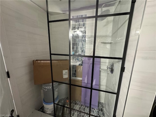 bathroom featuring tiled shower and tile walls