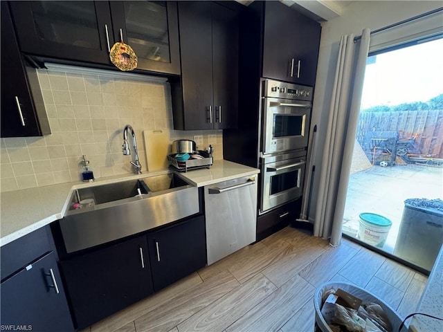 kitchen with tasteful backsplash, appliances with stainless steel finishes, and sink