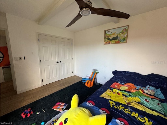 bedroom with beamed ceiling, dark hardwood / wood-style floors, and a closet