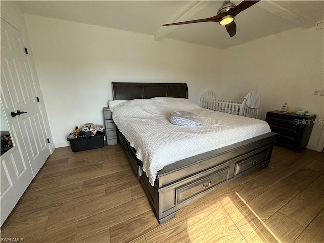 bedroom featuring beam ceiling, wood-type flooring, and ceiling fan