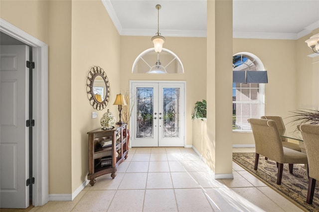 foyer entrance with crown molding, light tile patterned flooring, and french doors