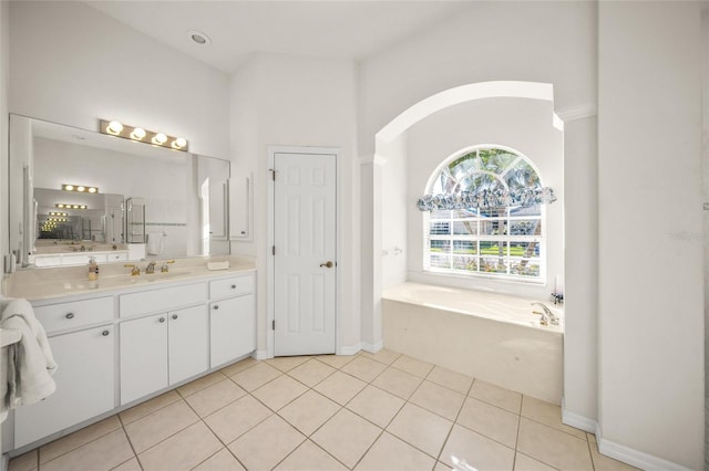 bathroom with tile patterned flooring, vanity, and a tub