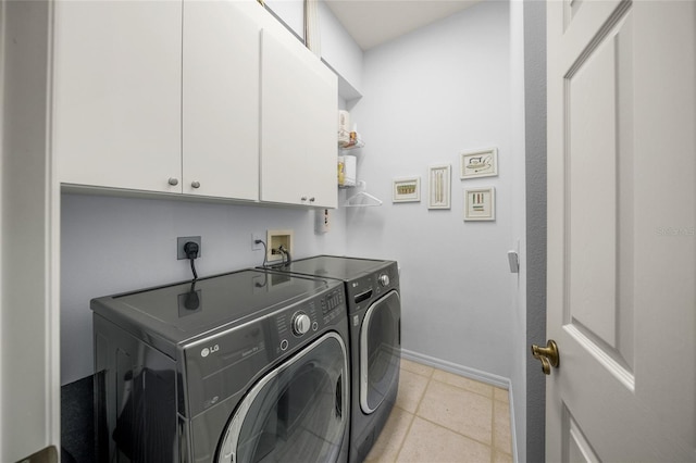 laundry room with washer and dryer, light tile patterned floors, and cabinets