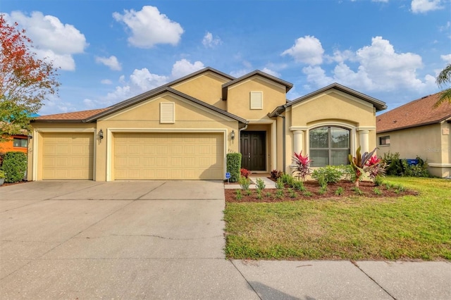 view of front of property featuring a front yard, an attached garage, driveway, and stucco siding