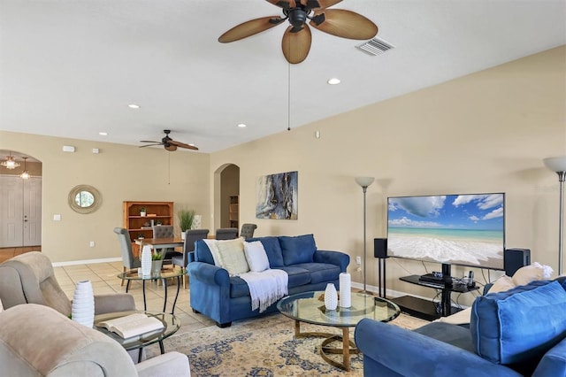 living room with light tile patterned floors, visible vents, baseboards, arched walkways, and ceiling fan