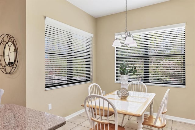 dining room featuring a wealth of natural light, light tile patterned floors, and baseboards