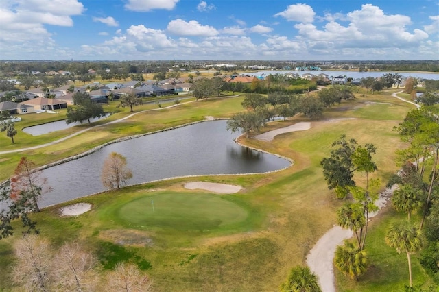 drone / aerial view with golf course view and a water view