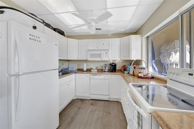 kitchen featuring light hardwood / wood-style flooring, white appliances, a paneled ceiling, and white cabinets