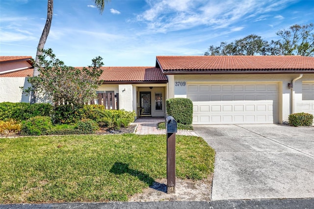 mediterranean / spanish-style house featuring a garage and a front yard