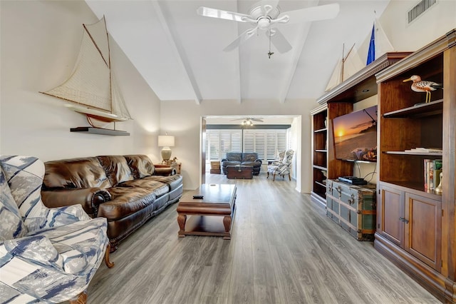 living room featuring ceiling fan, lofted ceiling with beams, and light wood-type flooring