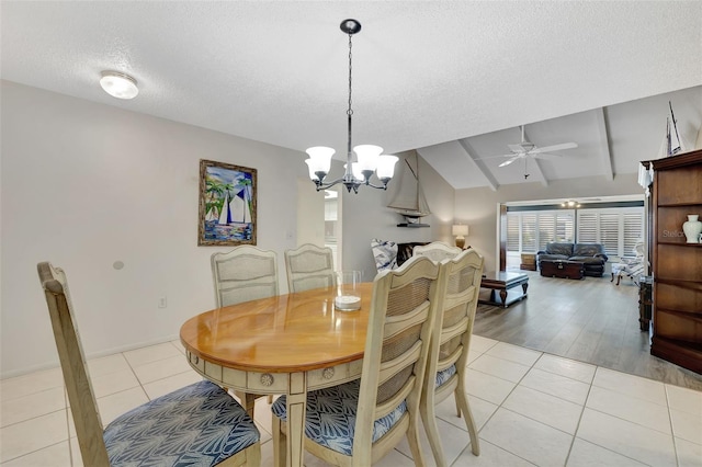 tiled dining room featuring vaulted ceiling with beams, ceiling fan with notable chandelier, and a textured ceiling